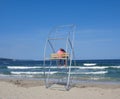 A loving couple is sitting on a beach rescue rig during a small storm