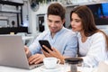 Loving couple sitting in cafe using laptop computer and mobile phone Royalty Free Stock Photo