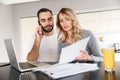 Loving couple sitting at the kitchen using laptop computer and work with documents Royalty Free Stock Photo