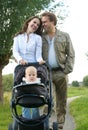 Loving couple smiling together and walking with baby outdoors Royalty Free Stock Photo