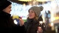 Loving couple with sparklers smiling, looking into eyes in winter city at night, Merry Christmass and New Year concept Royalty Free Stock Photo