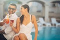 Loving couple spending vacation on tropical resort swimming pool.Newlyweds honeymoon on seaside Royalty Free Stock Photo