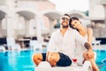 Loving couple spending vacation on tropical resort swimming pool.Newlyweds honeymoon on seaside Royalty Free Stock Photo