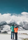 Loving couple standing and looking on beautiful snowy mountains peaks. Vertical panoramic view. Back view Royalty Free Stock Photo