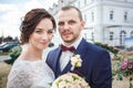 Loving couple of stylish newlyweds walks and kisses in the old city in summer sunny day