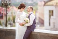 Loving couple of stylish newlyweds walks and kisses in the old city in summer sunny day