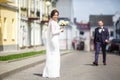 Loving couple of stylish newlyweds walks and kisses in the old city in summer sunny day