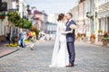 Loving couple of stylish newlyweds walks and kisses in the old city in summer sunny day