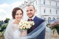 Loving couple of stylish newlyweds walks and kisses in the old city in summer sunny day