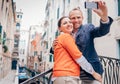 Loving couple take a selfie on the one of bridge over a channel