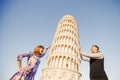 Loving couple takes selfie photo on stick and camera against background of leaning Tower Pisa, Italy. Travel concept Royalty Free Stock Photo