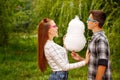 Loving couple teens eat cotton candy.
