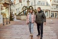 Loving couple of tourists walking around old town. Couple of lovers leisurely stroll in the cool autumn Royalty Free Stock Photo