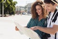 Loving couple traveling and reading map in city