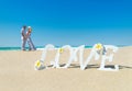 Loving couple at tropical ocean sandy beach with love word decor Royalty Free Stock Photo