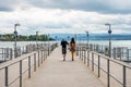 Loving couple walking at cruise ship dock at the Lake of Zurich with background of buldings at the lakeshore in Zurich, Royalty Free Stock Photo
