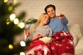 Loving couple watching tv at Christmas eve Royalty Free Stock Photo