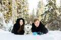 Loving couple in winter sunny forest with husky dogs in the snow Royalty Free Stock Photo