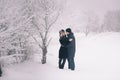 A loving couple on a winter walk. Snow love story, winter magic. Man and woman on the frosty street. The guy and the girl are rest Royalty Free Stock Photo