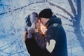 A loving couple on a winter walk. Snow love story, winter magic. Man and woman on the frosty street. The guy and the girl are rest Royalty Free Stock Photo