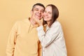 Loving couple woman and man wearing casual style clothing standing isolated over beige background looking at camera with love and