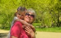 Loving cute granddaughter hugging her grandmother. Happy family.  Having good times with grandparent outdoors Royalty Free Stock Photo