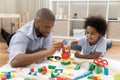 Loving dad and son engaged in game with construction cubes Royalty Free Stock Photo