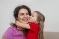 Loving daughter hugging and kissing her mother at home