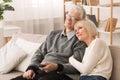 Loving Elderly Couple Watching TV, Resting At Home