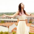 Loving every moment. Gorgeous young woman standing on a rooftop with her arms outstretched. Royalty Free Stock Photo