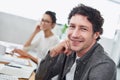 Loving every moment of his job. Portrait of two smiling designers sitting at their workstations in an office.