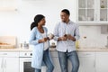 Loving expecting black family drinking coffee in kitchen