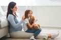 Loving expecting mother brushing her little daughter hair