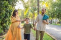 A loving family enjoying a leisurely walk in the park - a radiant pregnant woman after 40, embraced by her husband Royalty Free Stock Photo