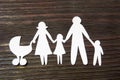 Loving family holding hands. Paper figures on a background of mahogany.
