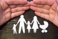 Loving family holding hands. Paper figures on a background of mahogany.