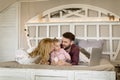 Loving family looking at a laptop lying down on bed in bedroom Royalty Free Stock Photo