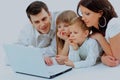 Loving family looking at a laptop lying down on bed at home. Royalty Free Stock Photo