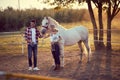 Loving family of three and a horse. Young happy family having fun at countryside outdoors. Summertime Royalty Free Stock Photo