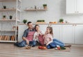 A loving family of three, sitting on the kitchen floor, smiling cheerfully at the camera while cooking. father,