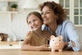 Dreamy mom and small child saving money for future vacation