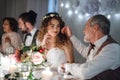 A loving father and beautiful bride sitting at the table on a wedding, talking.