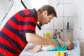 Loving father changing diaper of his newborn baby daughter. Royalty Free Stock Photo