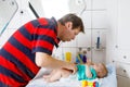 Loving father changing diaper of his newborn baby daughter. Little child, girl on changing table in bathroom with rattle