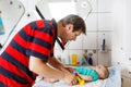 Loving father changing diaper of his newborn baby daughter. Royalty Free Stock Photo