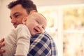 Loving Father Cuddling Baby Son Resting Over Shoulder At Home Together Royalty Free Stock Photo