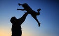 Loving father and his little son having fan together outdoors. Family as silhouette on sunset Royalty Free Stock Photo
