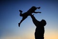 Loving father and his little son having fan together outdoors. Family as silhouette on sunset. Royalty Free Stock Photo