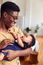 Loving Father Holding Newborn Baby At Home In Loft Apartment