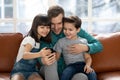Loving father makes selfie with children using smartphone. Royalty Free Stock Photo